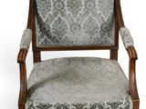 an upholstered chair with a damask upholstered back and arms