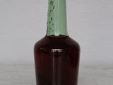 a brown bottle with a green top sitting on a table