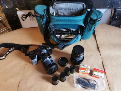 un sac bleu contenant un appareil photo et quelques autres objets, posé sur la table