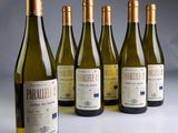 six bouteilles de vin sont alignées sur une table
