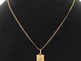 un collier plaqué or avec un pendentif en forme de palmier, posé sur le cou d'un mannequin