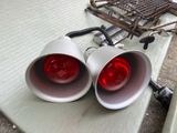two red lights sitting on a table next to a grill