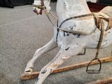 a wooden rocking horse that is sitting on the floor