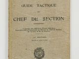 un vieux livre posé sur une table à côté d'un mur blanc