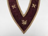 a close up of a purple and gold apron