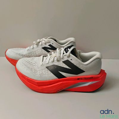 a pair of new balance shoes on a white surface