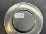 a silver plate that has a sticker on it