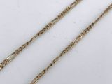 a close up of two gold chains on a white surface