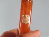 a person holding a piece of glass with a gold lion on it