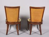pair of chairs with cane backrests and upholstered seats