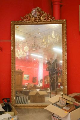 a large mirror in the middle of a room with a red wall