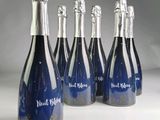 six bottles of blue wine are lined up in a row