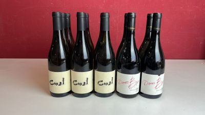 six bouteilles de vin sont alignées sur une table