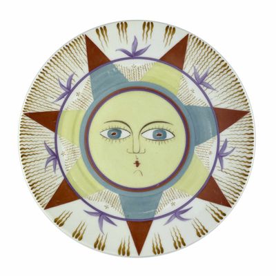 une assiette décorative sur laquelle figure un visage sur fond blanc