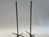 a pair of black metal candles on stands with a white background