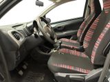the interior of a small car with a red and black seat cover