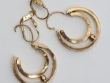 une paire de boucles d'oreilles en or sur fond blanc