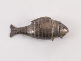 un objet argenté en forme de poisson posé sur une surface blanche