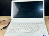 a white laptop computer sitting on top of a wooden table