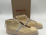 une paire de baskets beiges avec une chaîne sur le côté