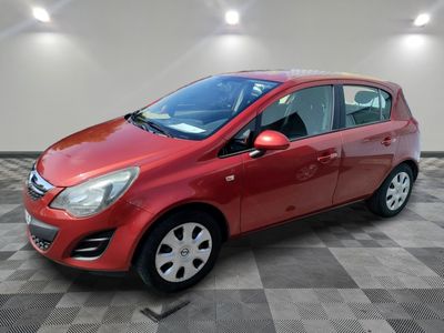 a red car is parked in a room with a checkered floor