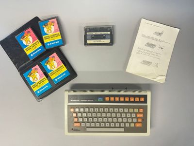 un clavier, un lecteur de cassettes et d'autres appareils électroniques posés sur une table