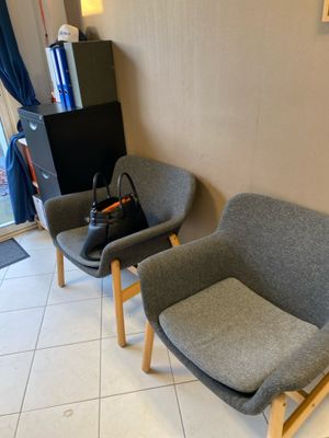 deux chaises dans un coin d'une pièce, avec un sac posé par terre
