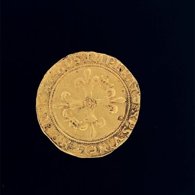 une vieille pièce d'or posée sur une surface noire, avec un fond noir