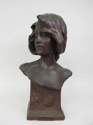 un buste en bronze représentant une femme coiffée d'un chapeau