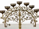 an ornate brass candelab with five candles and a crown on top