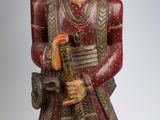 figurine en bois représentant un homme coiffé d'un turban et tenant une pipe