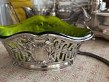 un bol en verre vert posé sur une table à côté d'une lampe