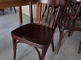 de nombreuses chaises en bois dans une pièce équipée d'une table et de chaises