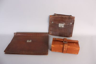 two pieces of brown leather on a white surface