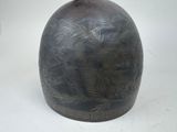 a black vase with a design on it sitting on a table