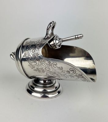 une lampe à huile ancienne en métal argenté, munie d'une poignée et d'une poignée
