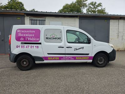 une camionnette garée sur un parking, avec un immeuble en arrière-plan