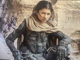 une photo d'une femme assise sur une moto, portant un foulard