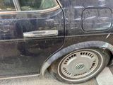 a black car with a flat tire parked on the side of the street
