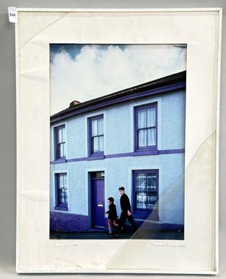 une photo d'un homme et d'une femme debout devant une maison bleue