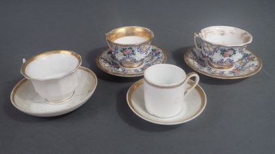 quatre tasses et soucoupes posées sur une table