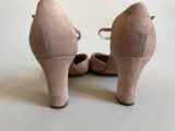 the back view of a pair of nude colored high heeled shoes