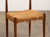 a close up of a chair with a woven seat on a wooden floor