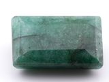 a close up of a green emerald stone on a white surface