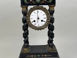 a black and gold clock sitting on top of a table