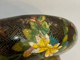 a close up of a vase with flowers painted on it