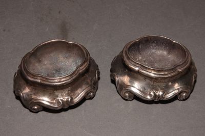 two silver bowls sitting on top of a table