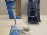 une brosse à dents posée sur une table à côté d'un tube de dentifrice
