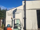 un chariot élévateur à fourche garé devant un bâtiment