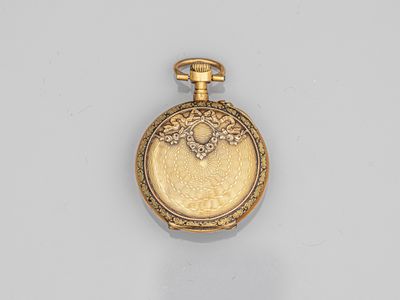 a close up of a gold pocket watch on a white surface